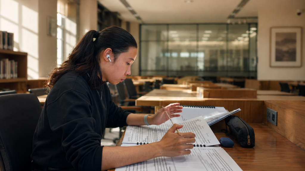 PhD student writing dissertation in a university library