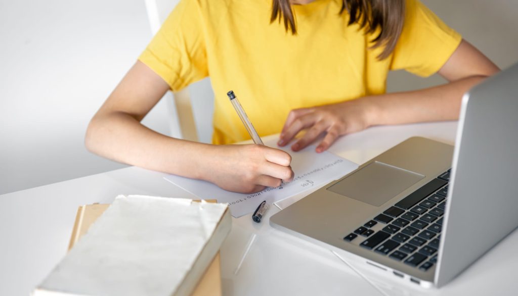 Student writing an essay on a laptop with AI text detection in mind