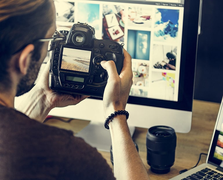Person examining a photo on a computer screen closely