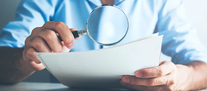 Magnifying glass examining a printed document