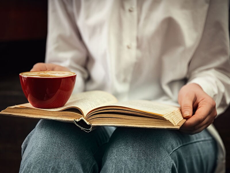 Person reading a book with coffee