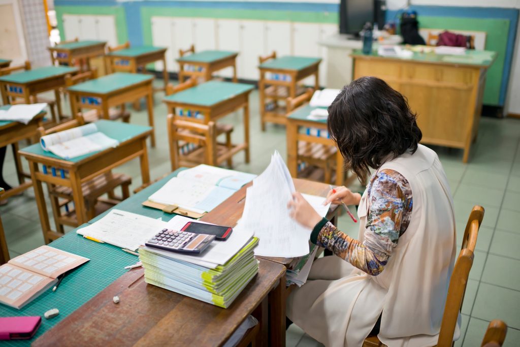 Teacher grading papers in a classroom